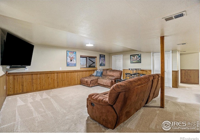 7889 Antelope Ct, Wellington, CO 80549 - carpeted living area featuring a wainscoted wall, visible vents, wooden walls, and a textured ceiling