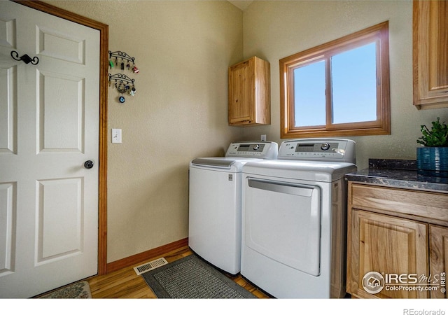 7889 Antelope Ct, Wellington, CO 80549 - laundry room featuring light wood-type flooring, baseboards, independent washer and dryer, visible vents, and cabinet space