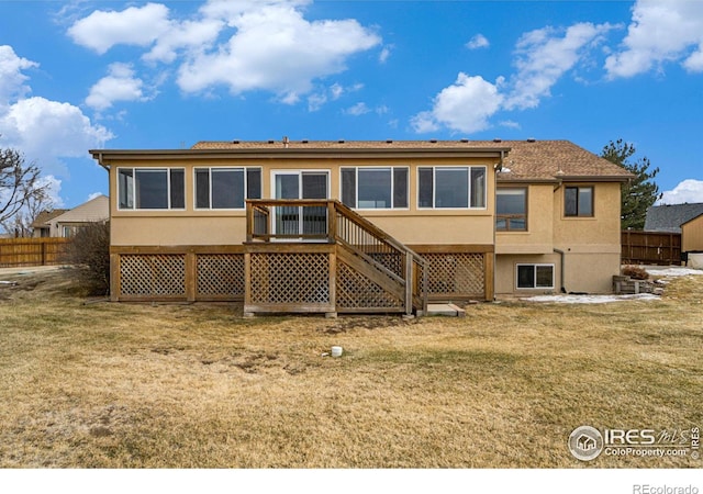 7889 Antelope Ct, Wellington, CO 80549 - back of property with stucco siding, fence, a lawn, and a wooden deck