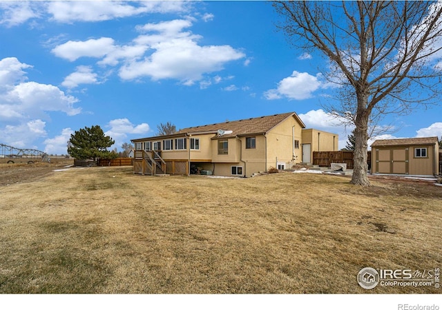 7889 Antelope Ct, Wellington, CO 80549 - rear view of property featuring an outdoor structure, stucco siding, stairway, fence, and a storage shed