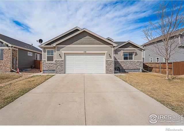 1108 Osprey Way, Wiggins, CO 80654 - craftsman-style house with stone siding, fence, an attached garage, a front yard, and driveway