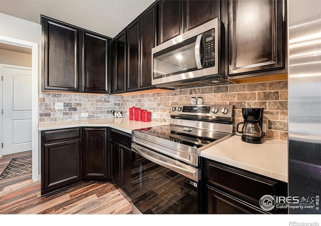 1108 Osprey Way, Wiggins, CO 80654 - kitchen featuring light wood finished floors, backsplash, light countertops, and appliances with stainless steel finishes