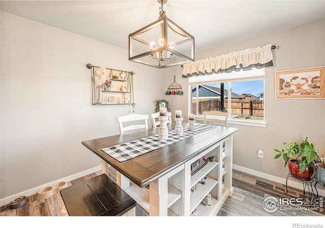 1108 Osprey Way, Wiggins, CO 80654 - dining room featuring baseboards, a notable chandelier, and wood finished floors