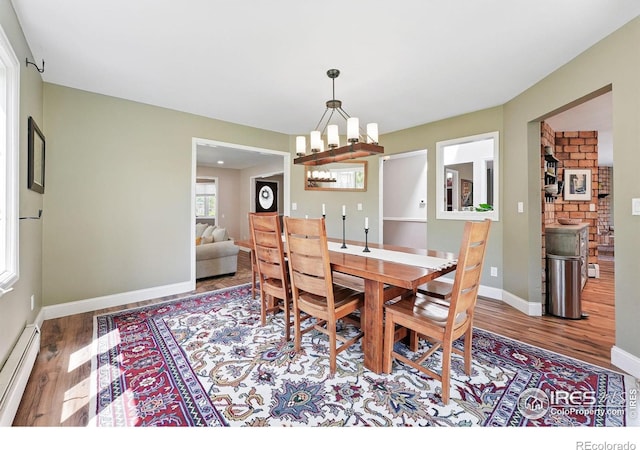 6850 Frying Pan Rd, Boulder, CO 80301 - dining area featuring a baseboard heating unit, wood finished floors, a chandelier, and baseboards