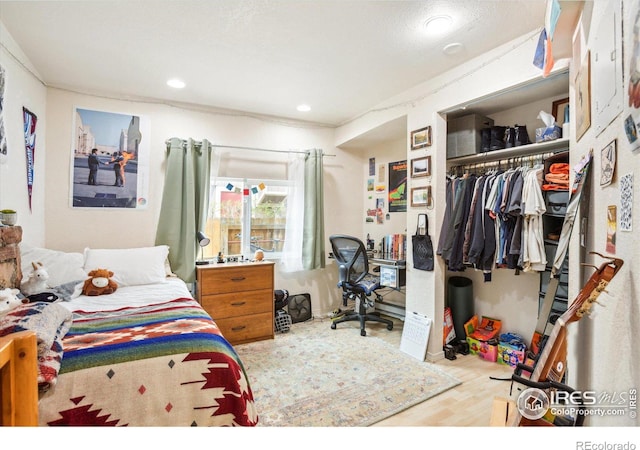 bedroom featuring a closet, wood finished floors, and recessed lighting