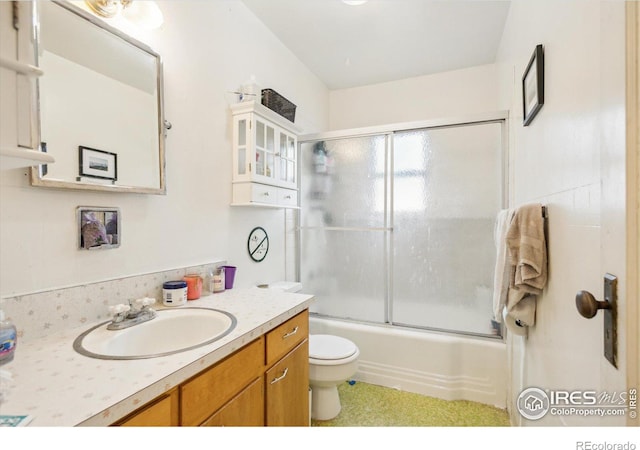 bathroom featuring bath / shower combo with glass door, toilet, and vanity