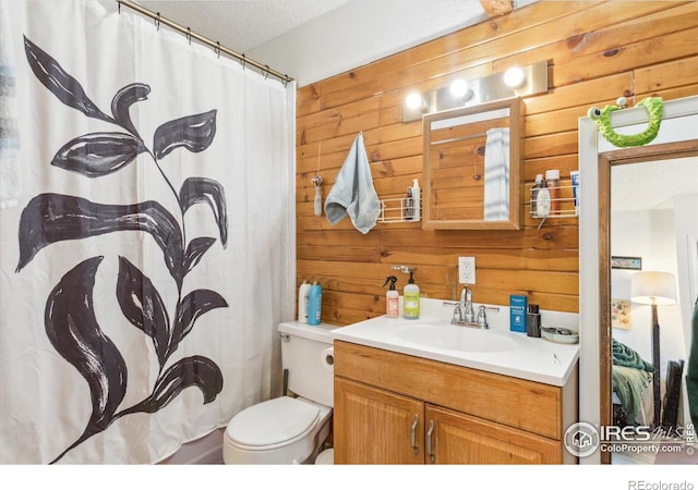 full bathroom featuring toilet, vanity, wood walls, and a shower with shower curtain
