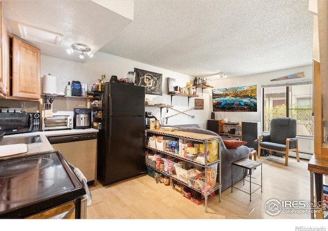 kitchen featuring light wood-type flooring, black appliances, light brown cabinetry, and a textured ceiling
