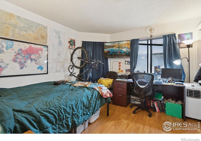 bedroom featuring a textured ceiling and wood finished floors