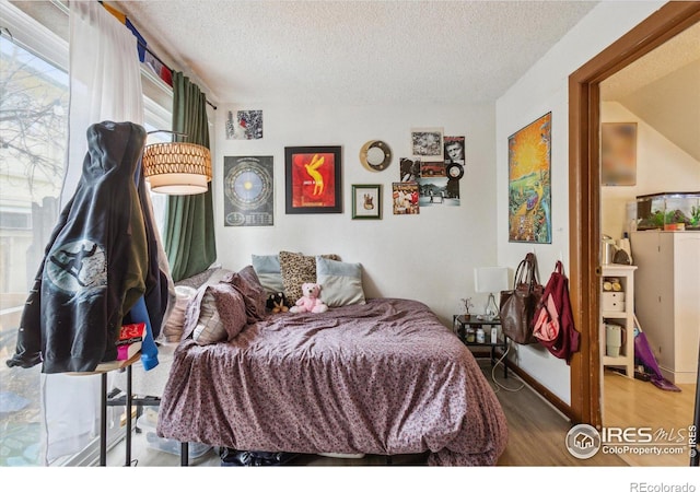 bedroom featuring a textured ceiling and wood finished floors