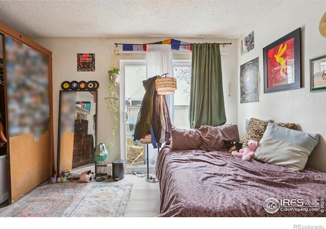 bedroom with wood finished floors and a textured ceiling