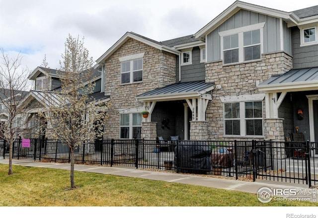 2449 Trio Falls Dr, Loveland, CO 80538 - view of front of property featuring fence private yard, board and batten siding, stone siding, and a standing seam roof