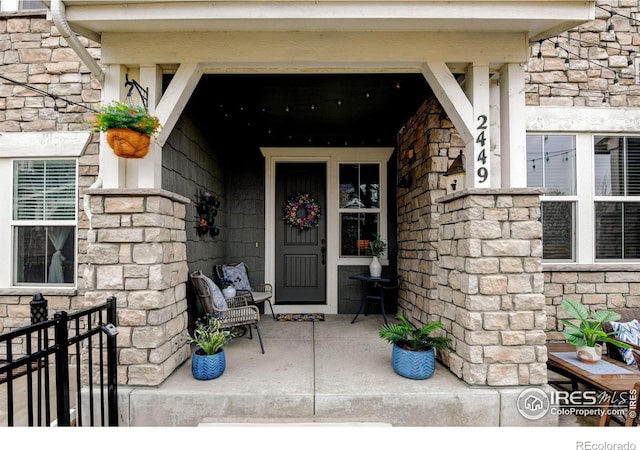 2449 Trio Falls Dr, Loveland, CO 80538 - property entrance with covered porch and stone siding