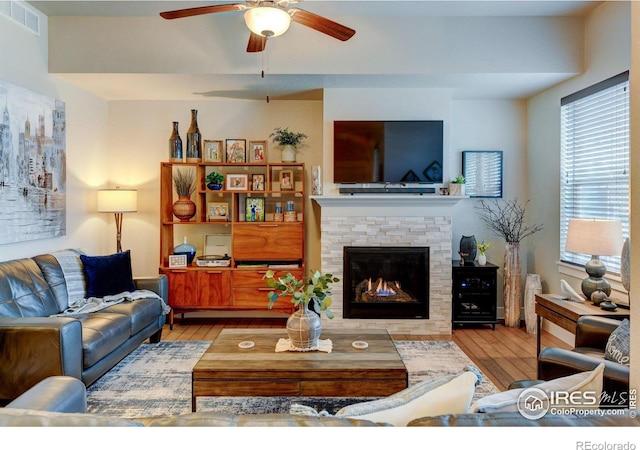 2449 Trio Falls Dr, Loveland, CO 80538 - living area featuring visible vents, ceiling fan, wood finished floors, and a fireplace