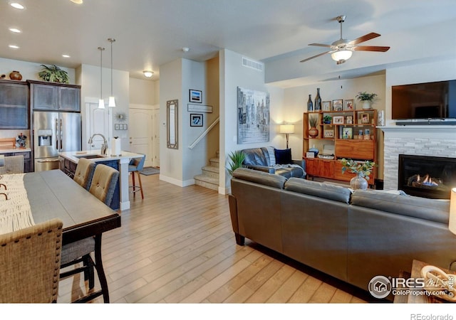 2449 Trio Falls Dr, Loveland, CO 80538 - living area with visible vents, stairs, baseboards, light wood-type flooring, and a ceiling fan