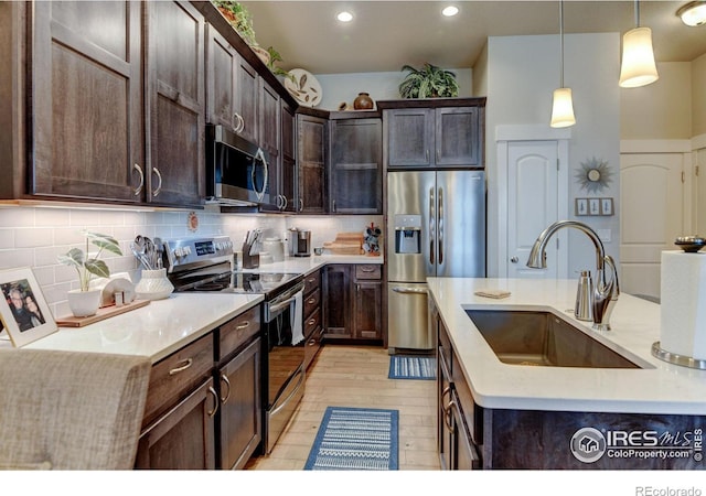 2449 Trio Falls Dr, Loveland, CO 80538 - kitchen featuring a sink, decorative backsplash, dark brown cabinetry, and stainless steel appliances