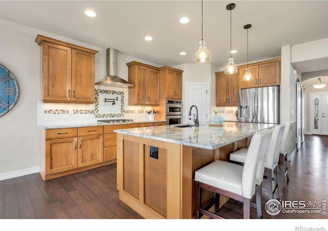 kitchen featuring backsplash, stainless steel appliances, wall chimney exhaust hood, and dark wood-type flooring