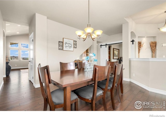 dining area with baseboards, a barn door, a chandelier, and dark wood-style floors