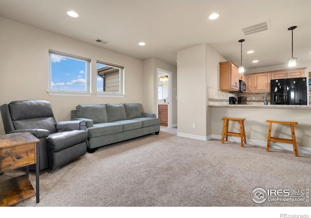 living room with recessed lighting, visible vents, and light carpet