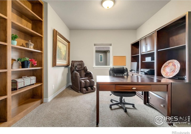 carpeted home office featuring baseboards