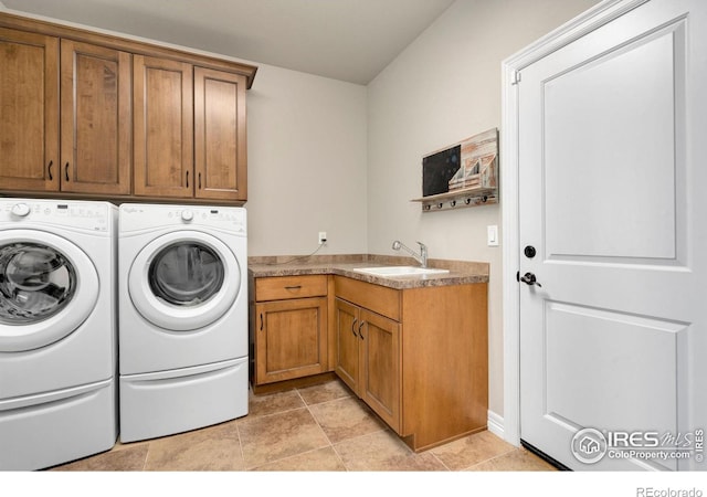 clothes washing area featuring a sink, cabinet space, and washing machine and clothes dryer