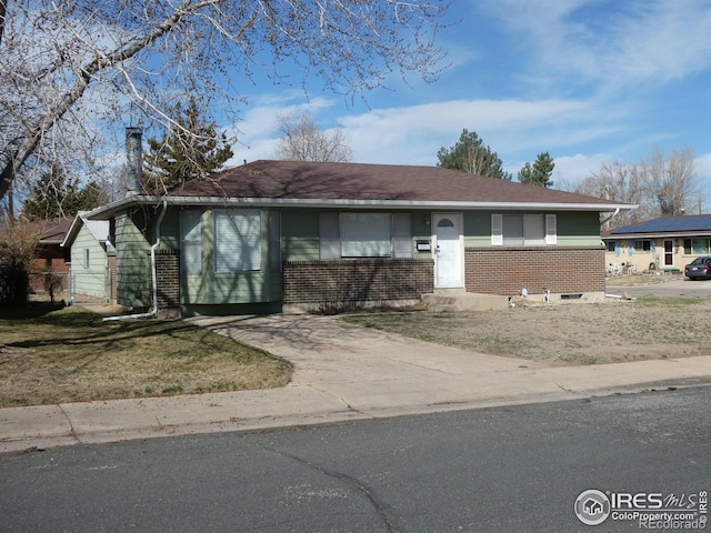 view of front of property with roof with shingles and brick siding