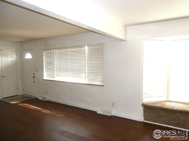 entrance foyer featuring visible vents, baseboards, and wood finished floors