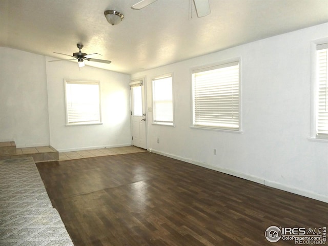 unfurnished living room with ceiling fan, wood finished floors, and baseboards