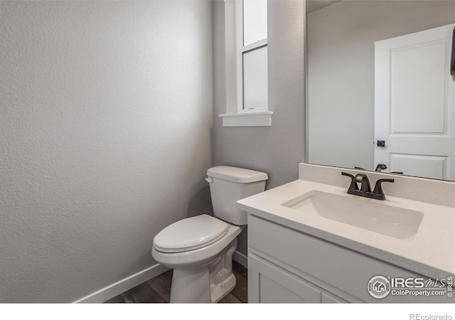 1219 105th Avenue Ct, Greeley, CO 80634 - bathroom with vanity, toilet, a textured wall, baseboards, and wood finished floors