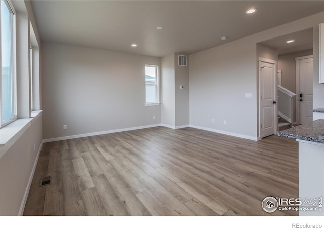 1219 105th Avenue Ct, Greeley, CO 80634 - unfurnished room featuring visible vents, light wood-style flooring, baseboards, stairway, and recessed lighting