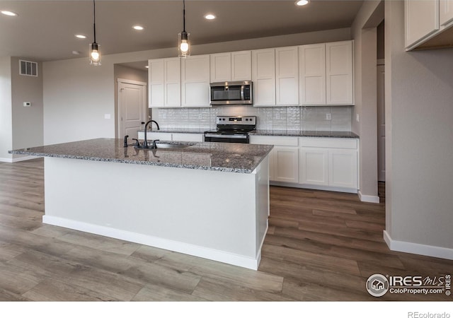 1219 105th Avenue Ct, Greeley, CO 80634 - kitchen with visible vents, dark stone counters, stainless steel appliances, white cabinetry, and a sink