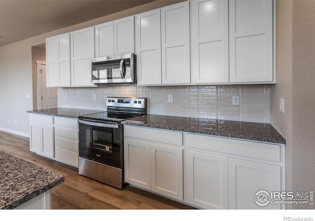 1219 105th Avenue Ct, Greeley, CO 80634 - kitchen featuring dark wood-type flooring, white cabinets, dark stone counters, and appliances with stainless steel finishes