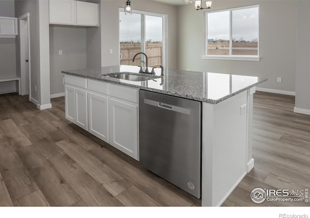 1219 105th Avenue Ct, Greeley, CO 80634 - kitchen with an island with sink, a sink, white cabinetry, light stone countertops, and stainless steel dishwasher