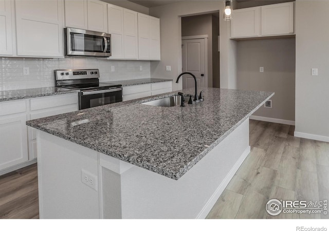 1219 105th Avenue Ct, Greeley, CO 80634 - kitchen with a sink, white cabinetry, backsplash, and appliances with stainless steel finishes