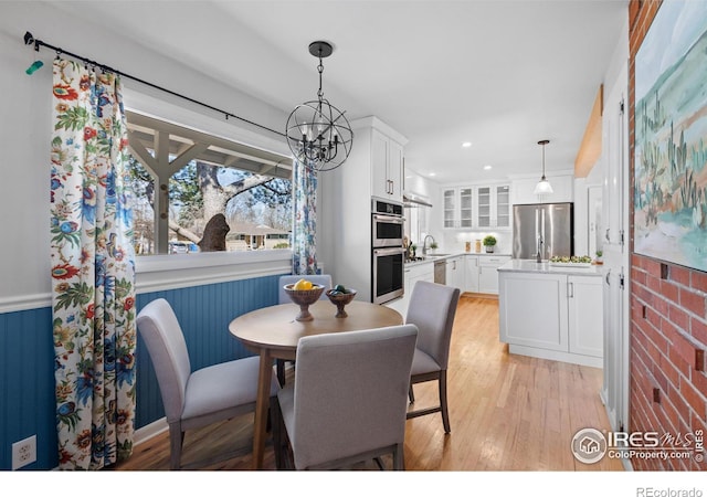 dining space featuring light wood-style flooring, recessed lighting, and an inviting chandelier