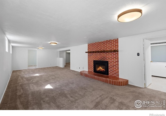 unfurnished living room with carpet, a fireplace, and a textured ceiling
