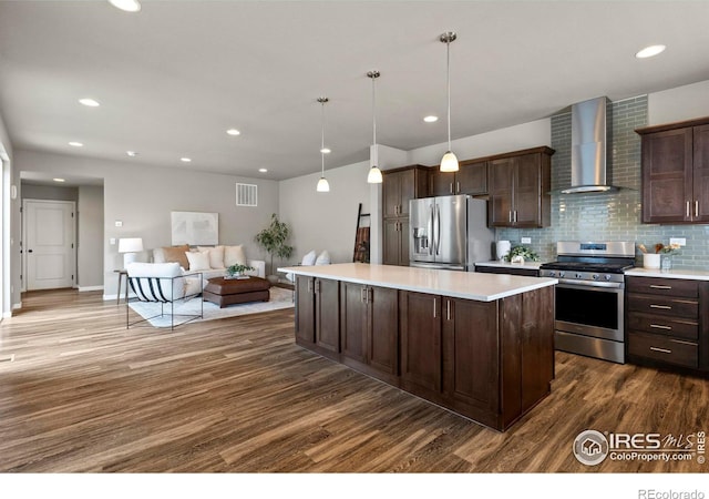 kitchen featuring visible vents, dark brown cabinets, appliances with stainless steel finishes, and wall chimney exhaust hood