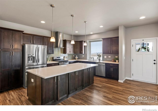 kitchen featuring dark wood-style floors, stainless steel appliances, wall chimney exhaust hood, and dark brown cabinets
