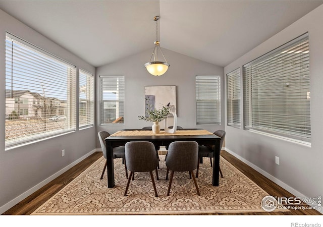 dining room with dark wood-style floors, lofted ceiling, and baseboards