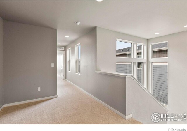 hallway featuring plenty of natural light, baseboards, recessed lighting, and carpet flooring