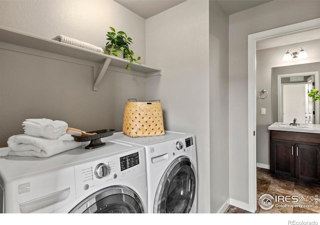 washroom with baseboards, separate washer and dryer, laundry area, and a sink