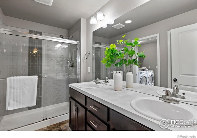 full bathroom with a shower stall, a sink, washer and clothes dryer, and visible vents