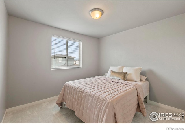 bedroom with light carpet and baseboards