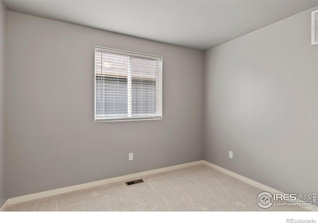 unfurnished room featuring baseboards, visible vents, and carpet