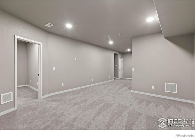 basement with light colored carpet, visible vents, and recessed lighting