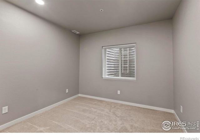 carpeted empty room featuring baseboards and visible vents