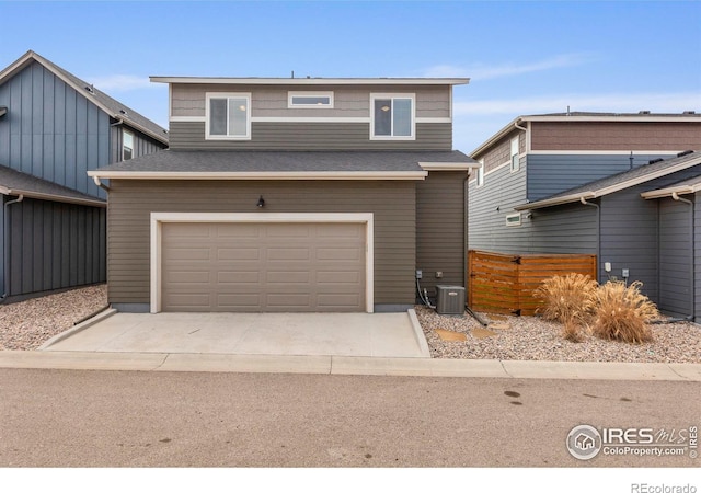 view of front of house with concrete driveway, central air condition unit, fence, an attached garage, and a shingled roof