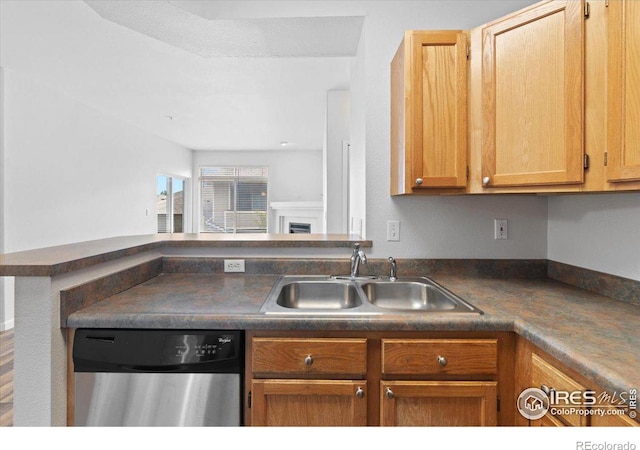 4545 Wheaton Dr Unit 310, Fort Collins, CO 80525 - kitchen with stainless steel dishwasher, dark countertops, a sink, and a fireplace