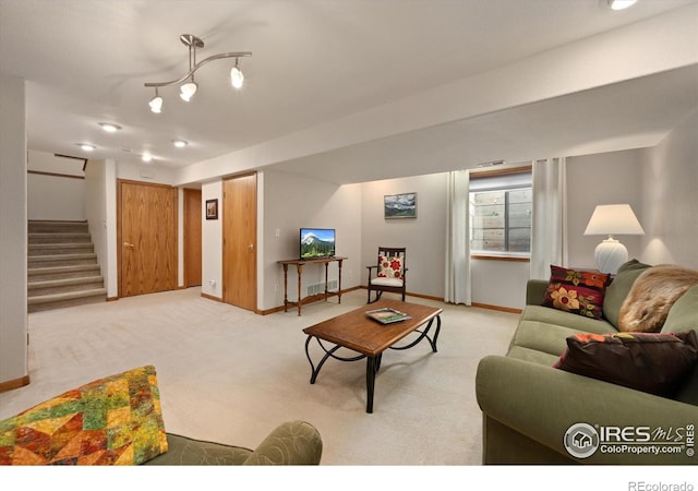 living room featuring baseboards, stairway, and light colored carpet