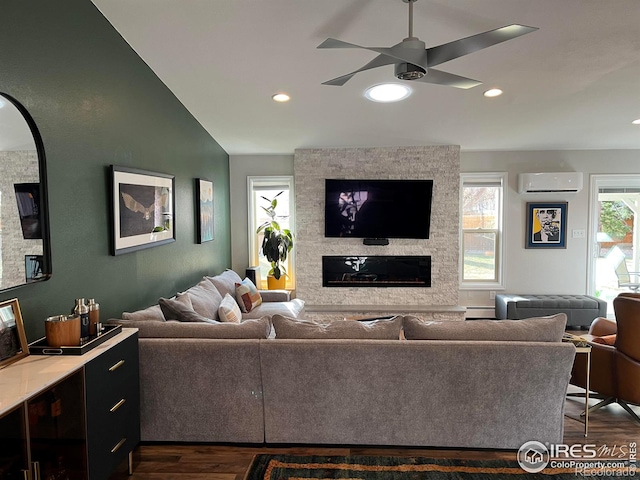 living area with dark wood-style floors, a stone fireplace, an AC wall unit, and ceiling fan